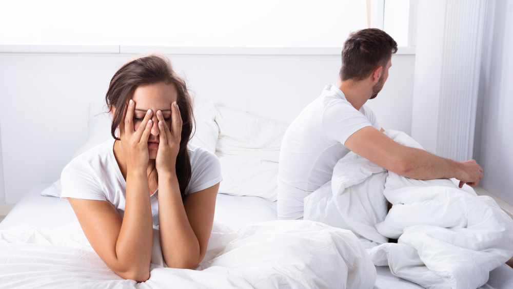 Couple in bed, woman with headache