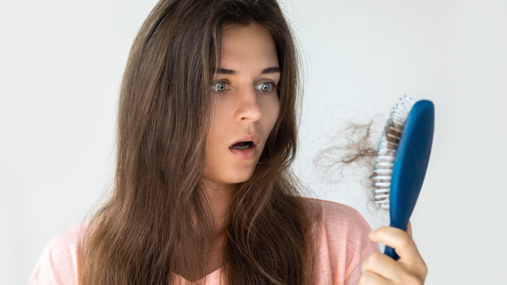 Woman shocked, holding hair brush