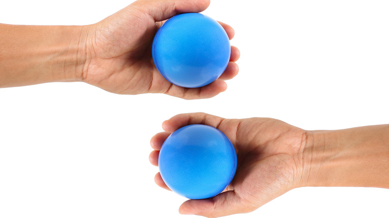 picture of two hands holding two large blue balls