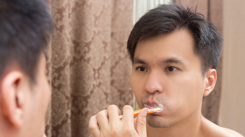 man brushing teeth