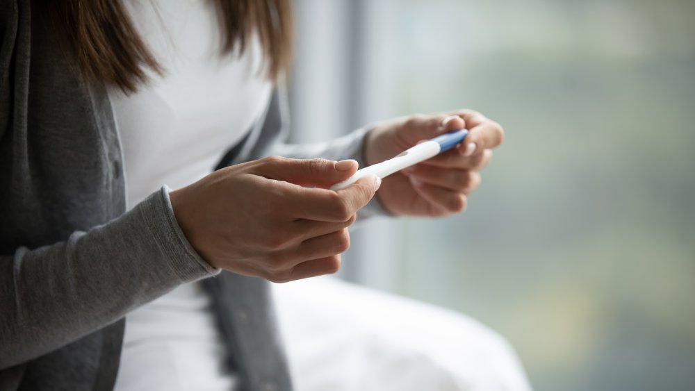 woman holding pregnancy test