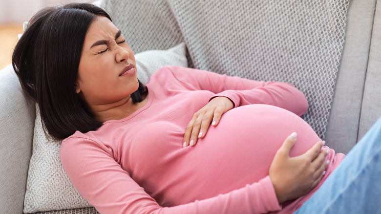 Woman lying on a couch experiencing labor pains