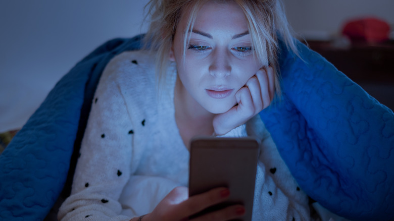 woman on phone in bed