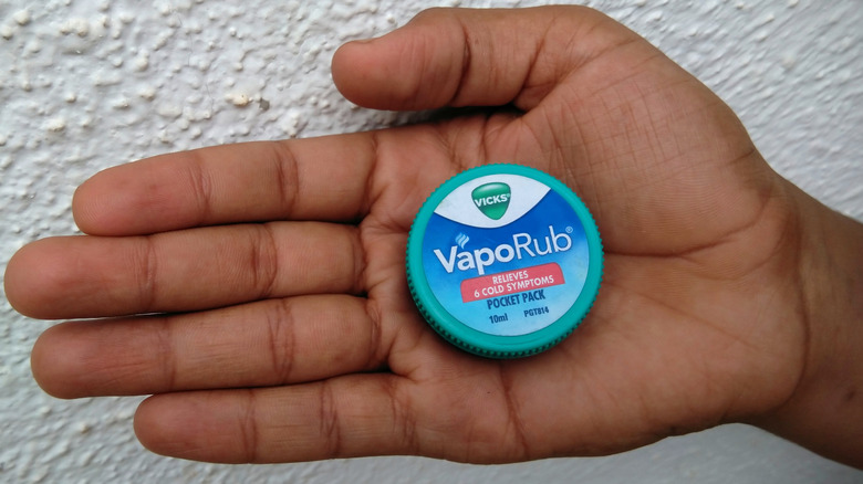 An open palm with a pocket pack of Vicks 