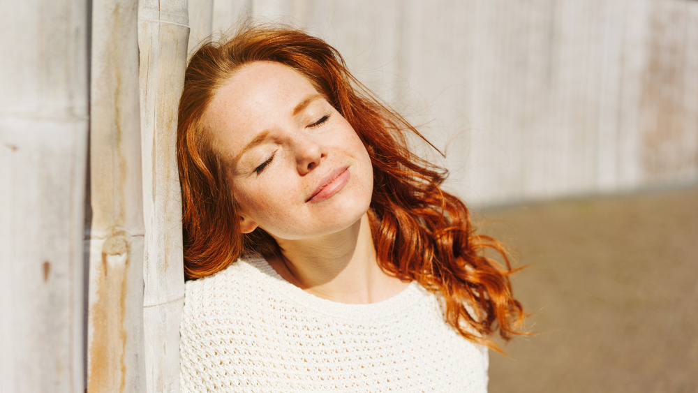 Redheaded woman basking in sun