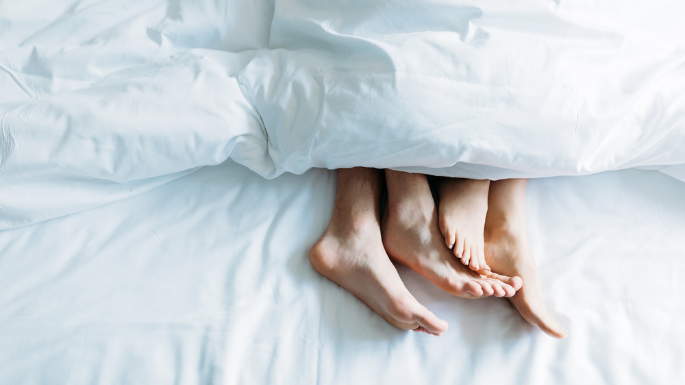 Couple's feet in bed