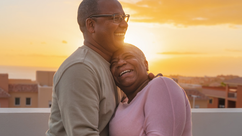 senior couple smiling outside embracing