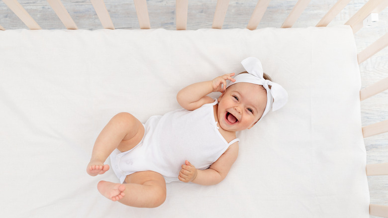 Baby girl smiling in crib