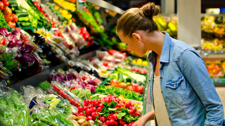 woman looking at fresh produce at the grocery store