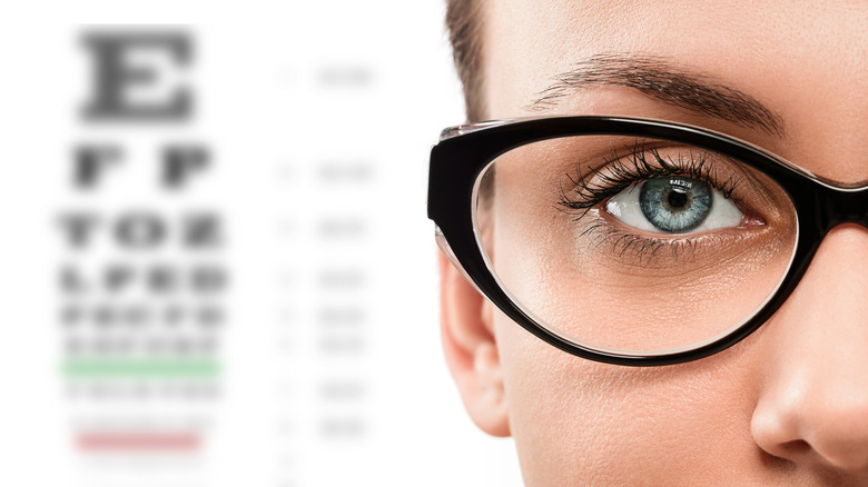 woman with glasses and a blurry eye chart