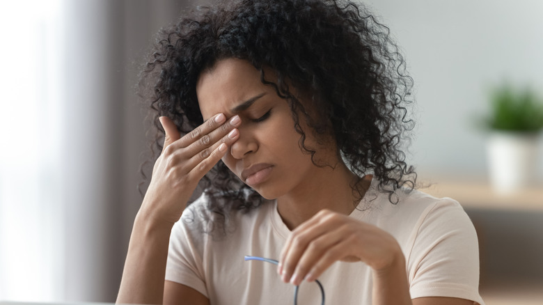 tired or fatigued woman holding her head