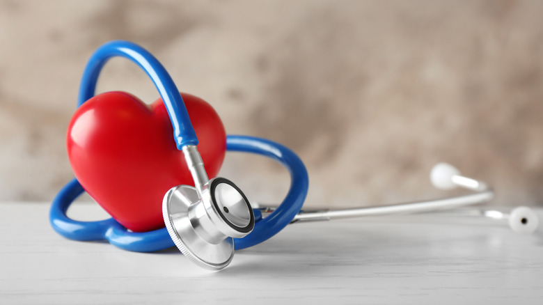 blue and silver stethoscope wrapped around a heart