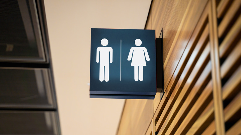 public restroom sign and a wooden wall