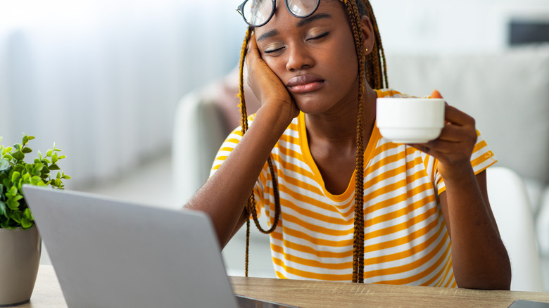 young woman falling asleep while working