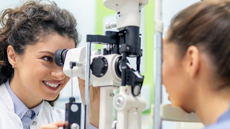 optometrist examines patient's eyes