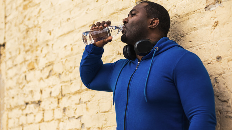 man drinking water outside