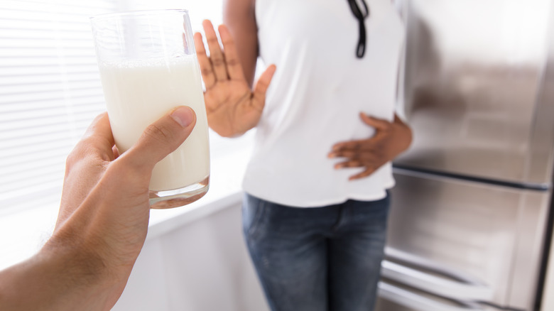 woman rejecting glass of milk