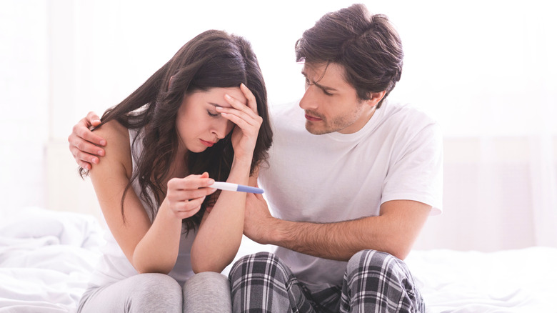 Sad couple with pregnancy test