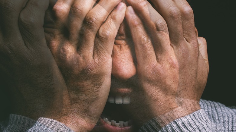 man holding his head with hands