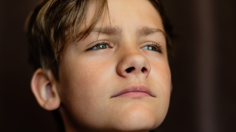 solemn boy on dark background