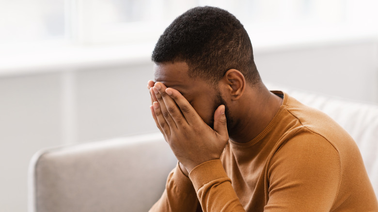 Man holding face in hands