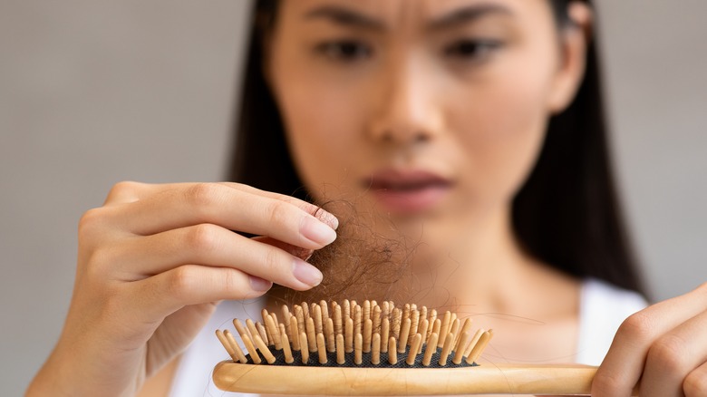 Woman concerned about hair in hairbrush