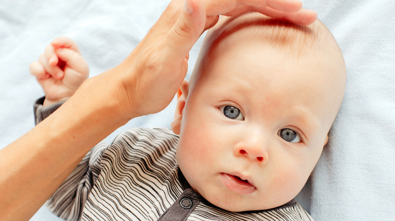 baby with parent touching head