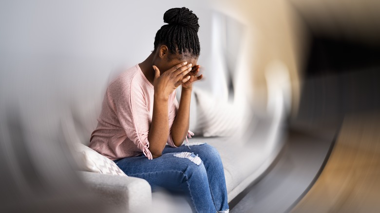 Woman with vertigo holding her head