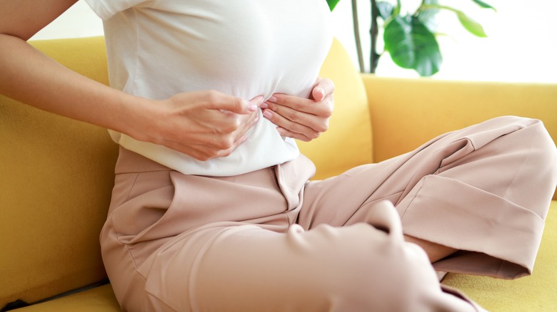 Woman pressing against pain in her belly