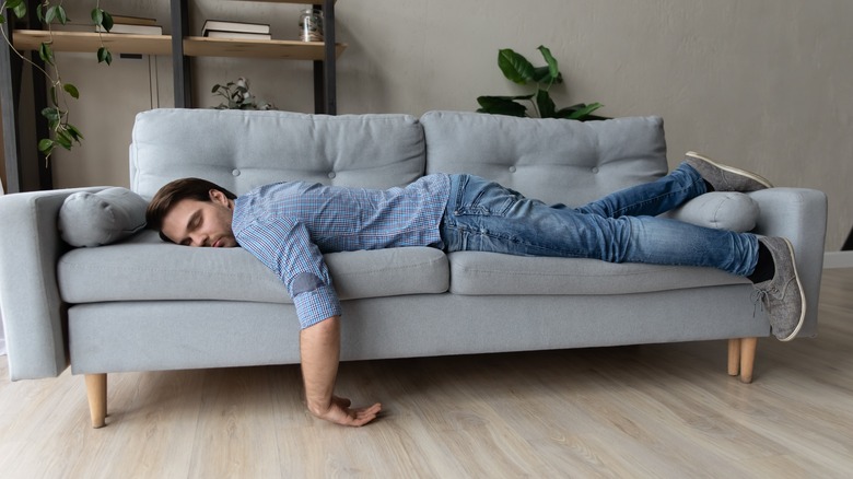 Man sleeping face down on couch