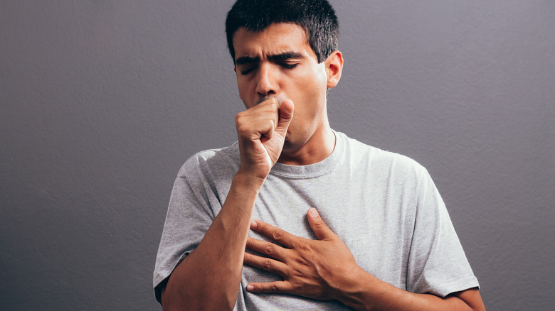 Man covering mouth while coughing