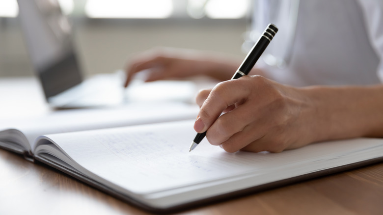 A person using a pen to write