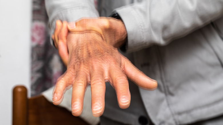 Distorted picture of a person holding their wrist