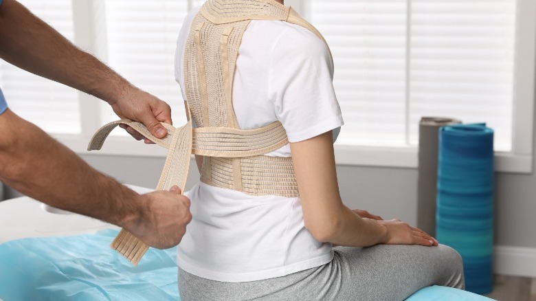 fitting scoliosis brace on woman