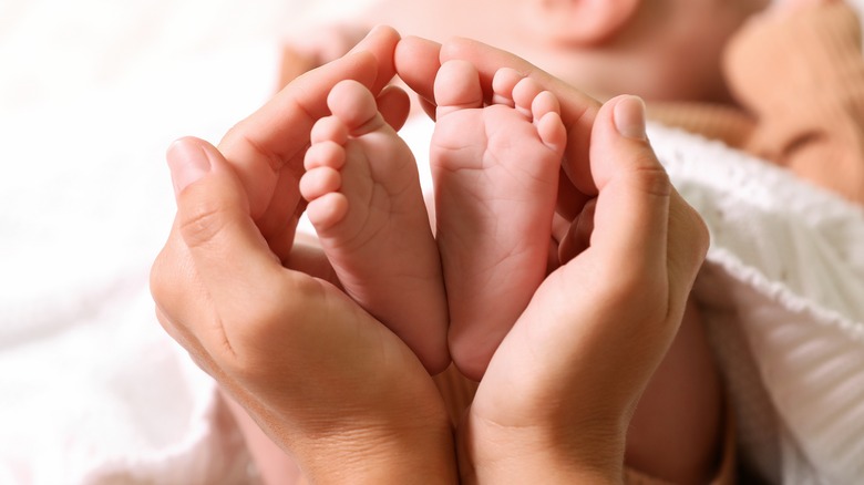 Hands holding newborn baby feet