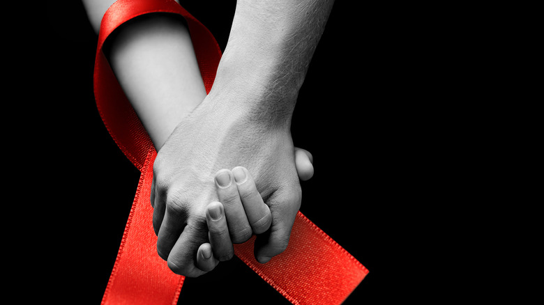 Red ribbon around holding hands