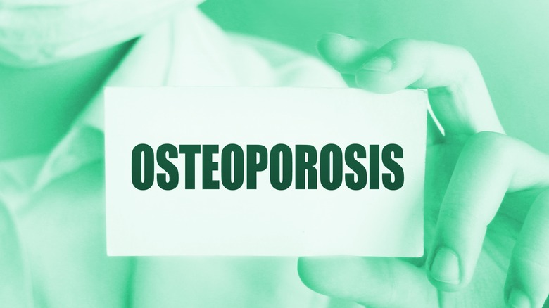 doctor in mask holding osteoporosis card 