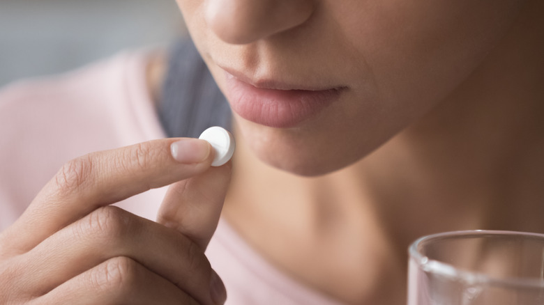 young girl taking a pill