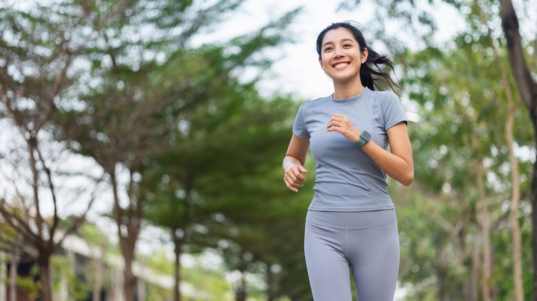 a woman smiles while jogging outside 