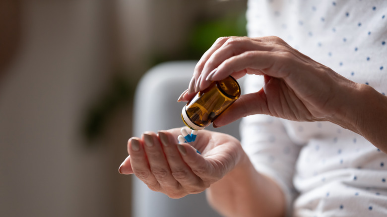 woman emptying a pill bottle