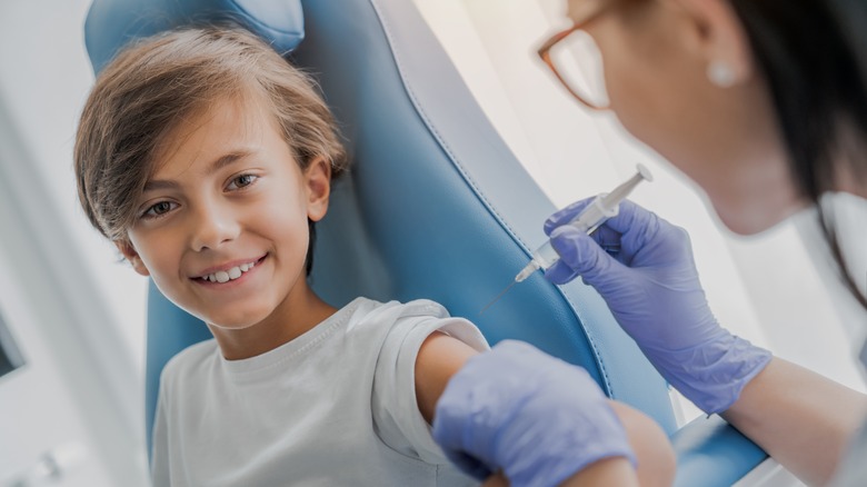 nurse injecting smiling kid's arm