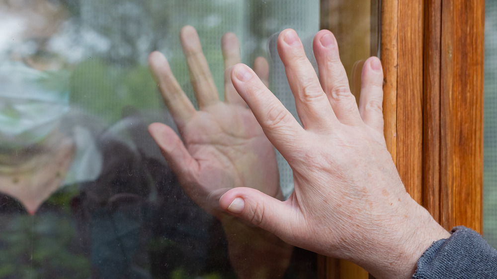 hands touching through glass
