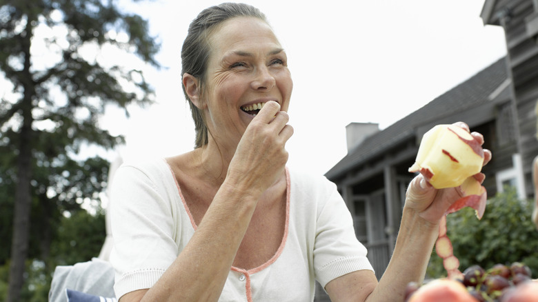 Happy woman eating an apple