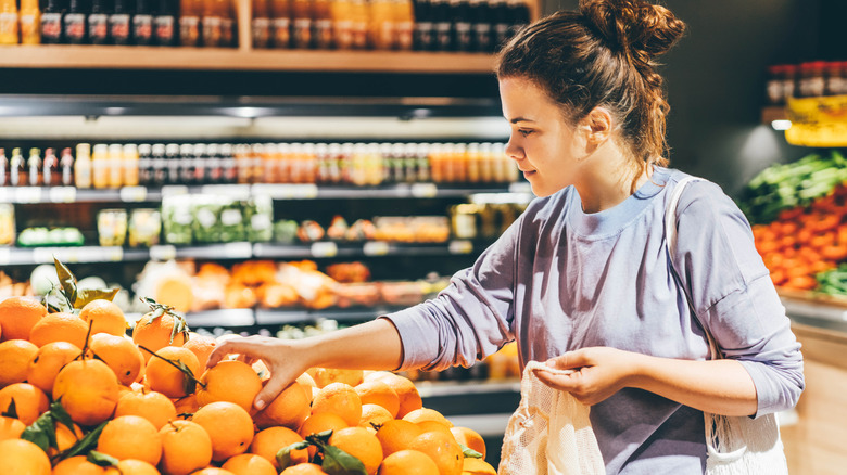 Woman buying oranges at the store