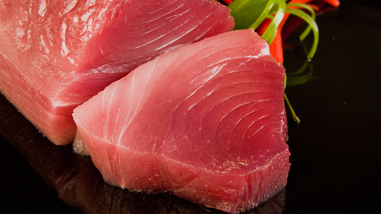 Raw tuna steak on black background