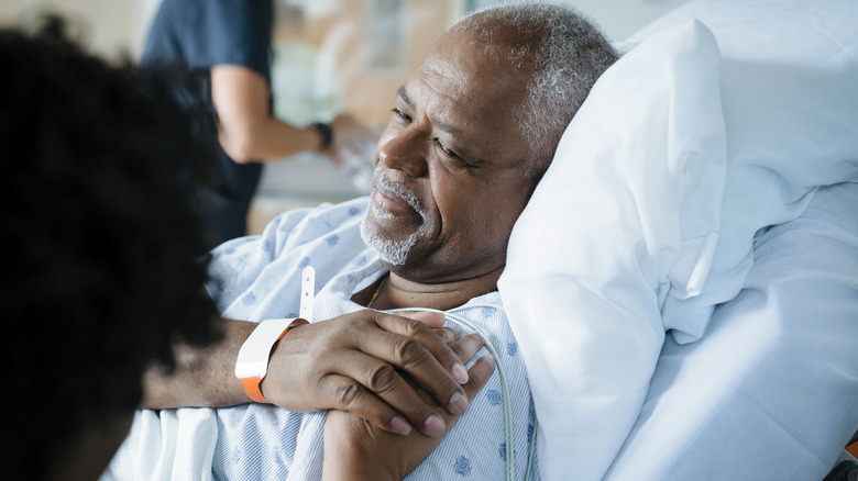 Patient holding a loved one's hand in hospital