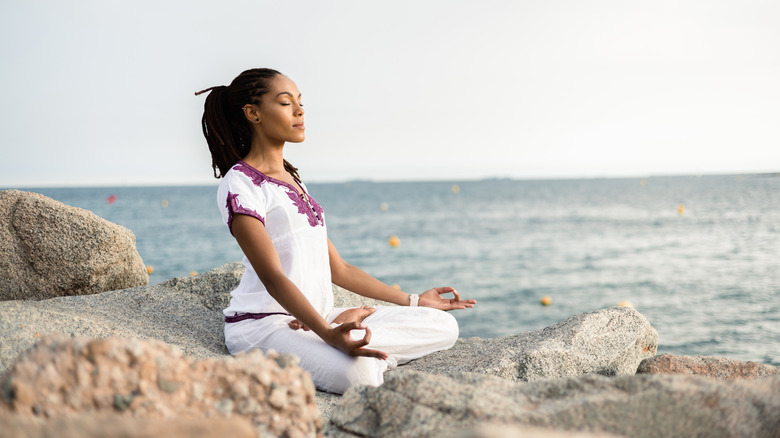 Woman meditating on beach