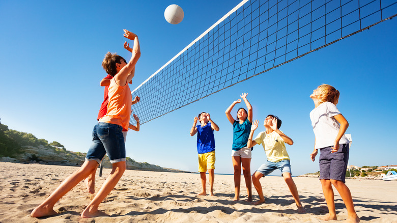 children playing volleyball on the beach