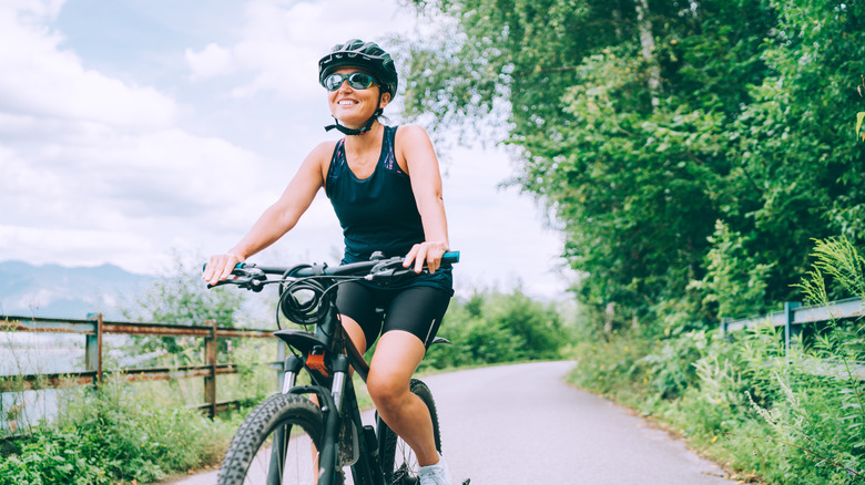 woman smiling riding her bike in the summer