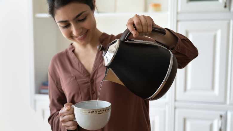 Woman pouring water in a teacup